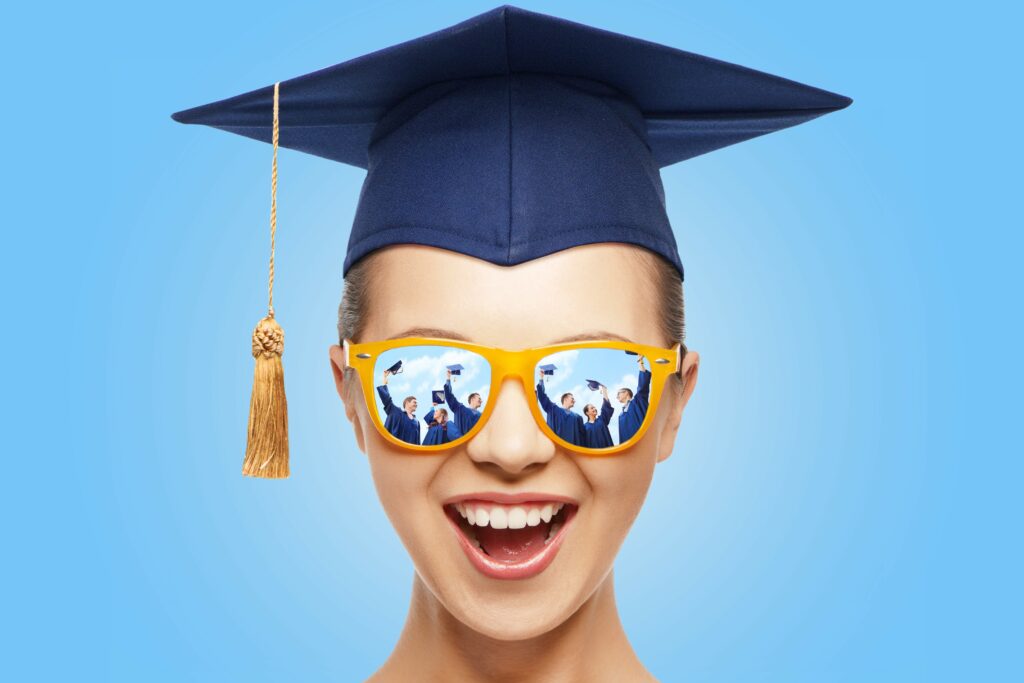 graduation, education, school and people concept - happy screaming teenage girl in shades and mortarboard or bachelor hat over blue background