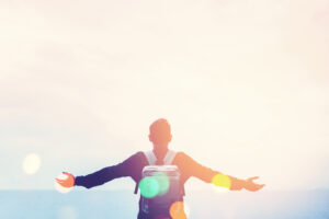 Copy space of man raise hand up on blue sky at beach and island background. Freedom and travel adventure concept. Vintage tone filter effect color style.