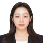 Portrait photo of Seyun Um, a woman with long dark hair, wearing a dark blazer over a white top