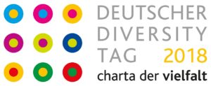 Neun in Dreierreihen symmetrisch angeordnete, mehrfarbige Punkte, umgeben von andersfarbigen Kreisen, geflogt vom Schriftzug DEUTSCHER DIVERSITY TAG 2018 charta der vielfalt