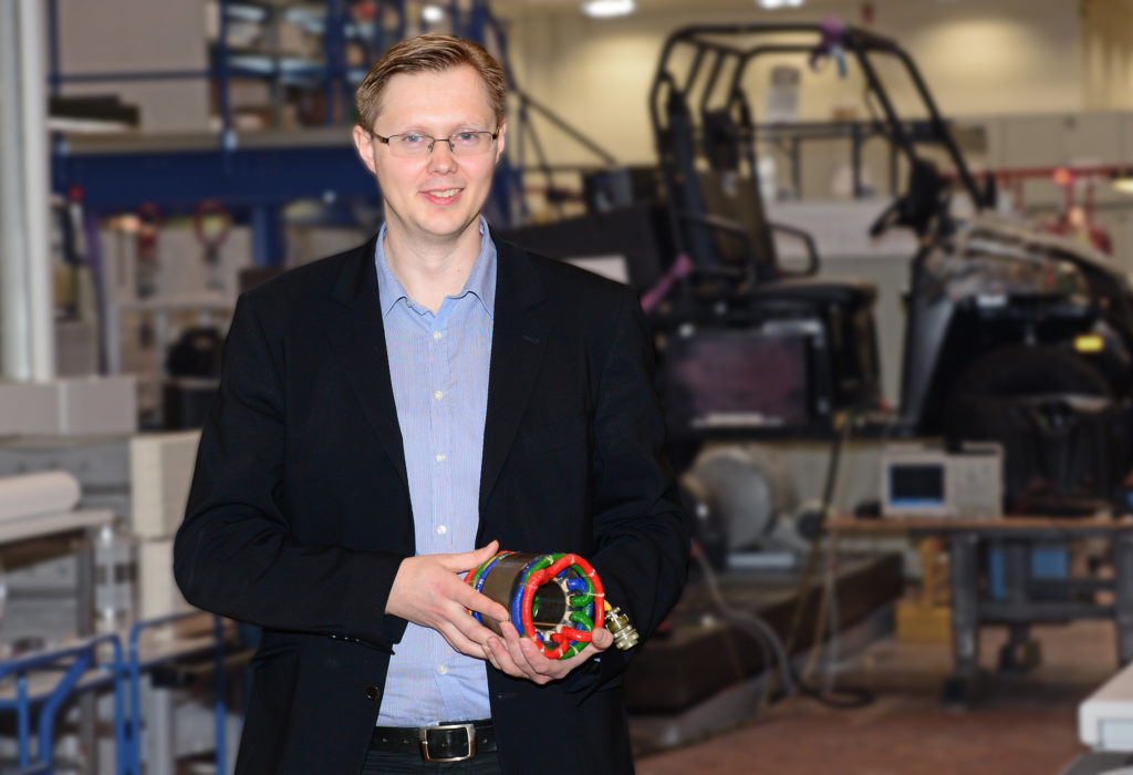 Ein mann, der ein Teil eines Elektromotors in der Hand hält