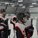 Eine Gruppe von Eishockeyspielern steht auf einer Eisfläche.