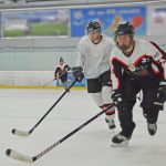 Drei Eishockeyspieler in vollem Lauf.