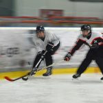 Zwei Eishockeyspielerinnen kämpfen um einen Puck.