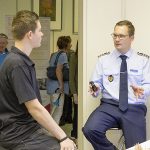 Ein Mann in Uniform spricht mit einem Jugendlichen.