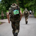 Soldaten laufen mit schweren Rucksäcken