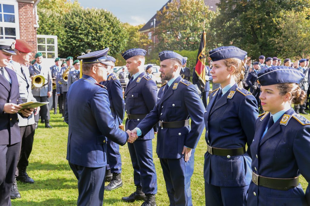 Ein General beglückwünscht Soldaten und Soldatinnen