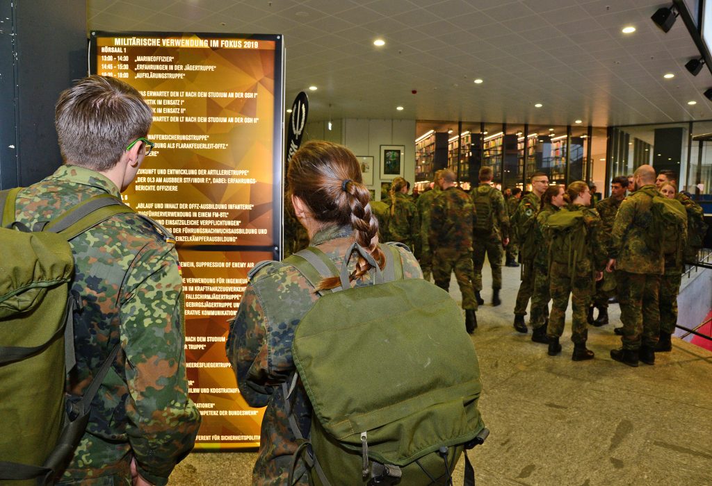 Zwei Soldaten stehen vor einer Informationswand