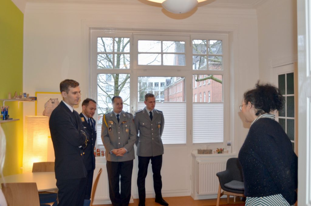 Eine Dame gibt vier Soldaten in Uniform eine Erläuterung.