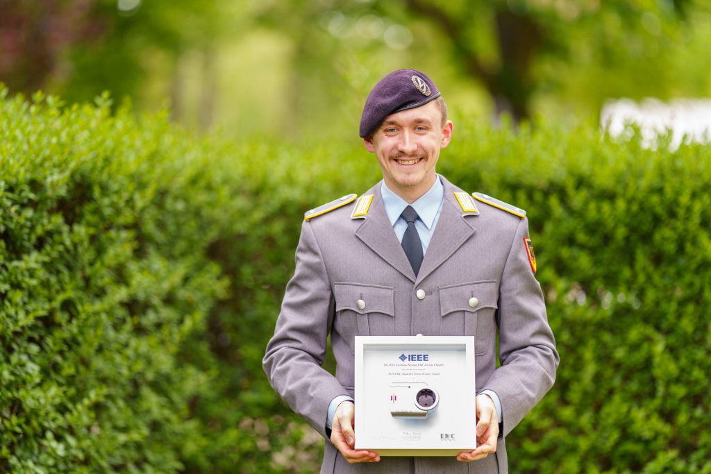 Ein Soldat in der Uniform eines Leutnants der Fernmeldetruppe des Heeres hält eine Urkunde in der Hand