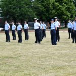 Eine Soldatin in einer Marineuniform steht vor anderen Soldatinnen und Soldaten und liest etwas vor.