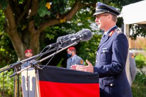 Ein Mann in der Uniform eines Generalmajors der Luftwaffe hinter einem Rednerpult