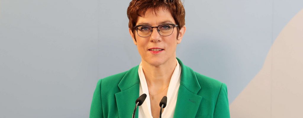 Eine Frau in einem grünen Blazer hinter einem Rednerpult