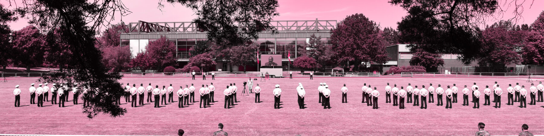 In Rot, der Farbe der Universität, eingefärbtes Panoramabild von angetretenen Soldaten auf einem Sportplatz