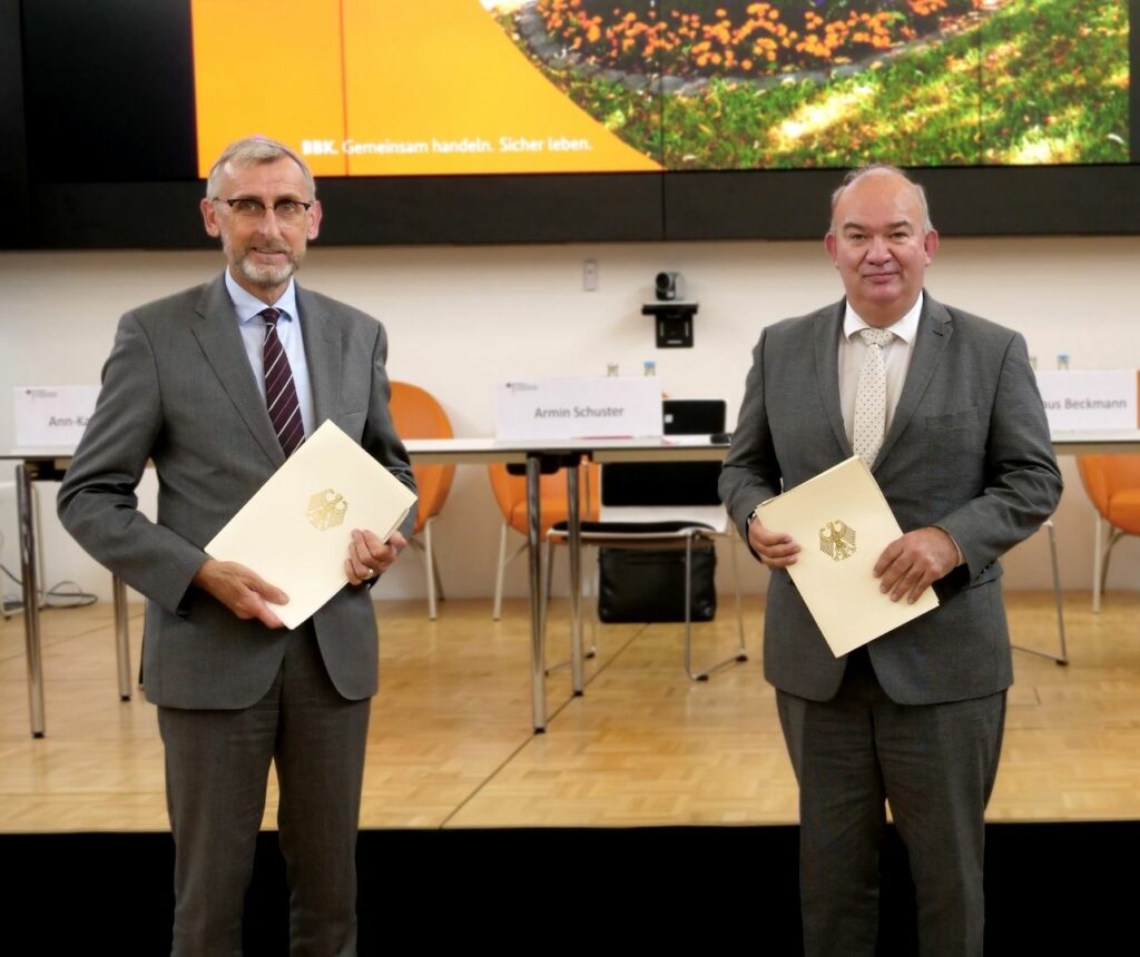 Armin Schuster, Präsident des Bundesamtes für Bevölkerungsschutz, und Prof. Dr. Klaus Beckmann, Präsident der Helmut-Schmidt-Universität / Universität der Bundeswehr, unterzeichnen die neue Lehrkooperation.