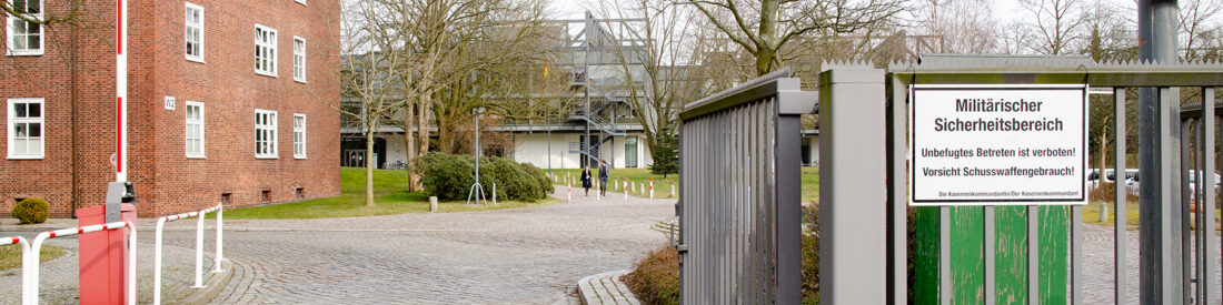 Blick auf die Ein- und Ausfahrt der Helmut-Schmidt-Universität am Holstenhofweg, im Vordergrund hängt zu Demonstrationszwecken ein Schild mit der Aufschrift "Militärischer Sicherheitsbereich"