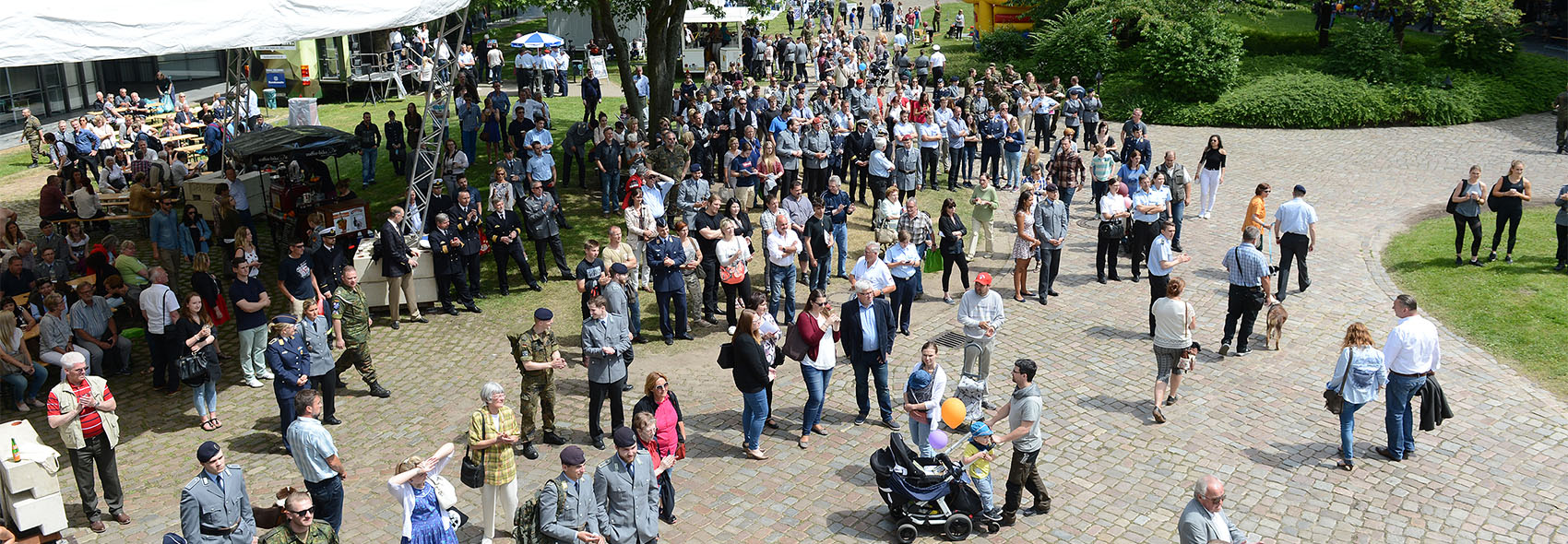 Menschentrauben stehen und gehen auf dem Campus. Es ist Tag der offenen Tür.