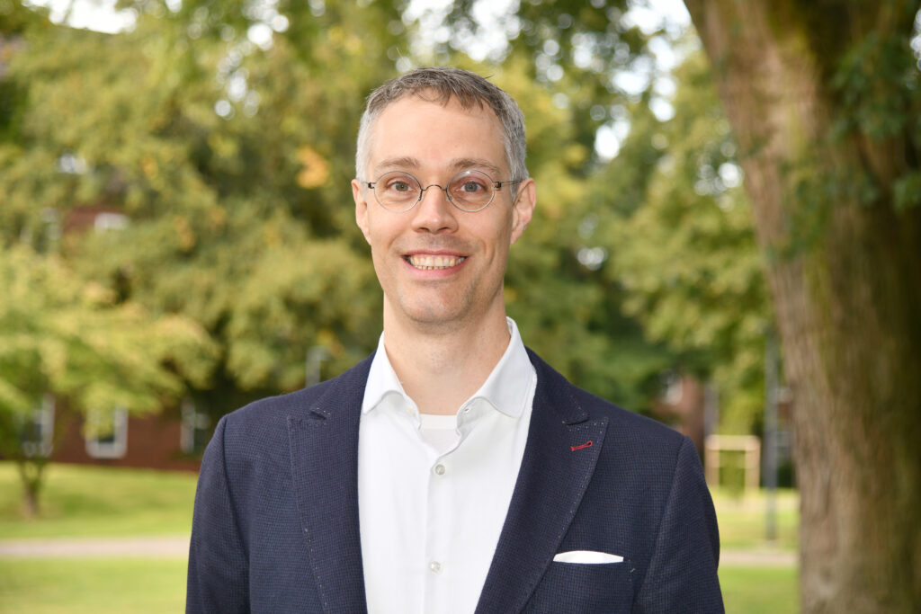 Prof. Dr. theol. habil. Gerhard Schreiber, Portrait vor einem Baum.