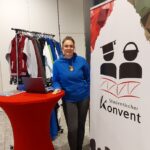 Vera Schmitt vom Studentischen Konvent beim Alumni-Tag 2023 mit Merchandising-Material der HSU/UniBw H