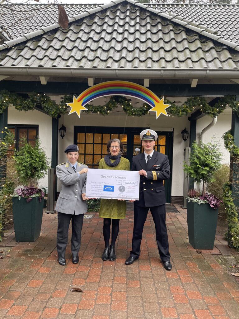 Leutnant Chiara Unali, und Kapitänleutnant Björn Hoppe übergeben den symbolischen Scheck  an Christiane Schüddekopf vom Kinderhospitz Sternenbrücke