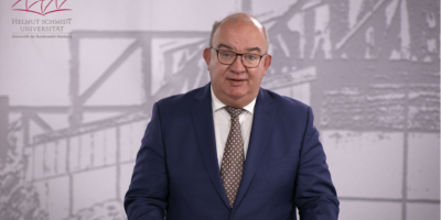 In dieser Videobotschaft spricht Universitätspräsident Prof. Dr. Klaus Beckmann über die Relevanz des Studiums für den Kompetenzerwerb unserer Offizieranwärterinnen, Offizieranwärter und Offiziere. Zudem stehen die Jahreshighlights 2025 im Mittelpunkt der Ansprache: Die HSU/UniBw H ist offizieller Bundespate sowie Austragungsort des Bundeswettbewerbs Jugend forscht 2025 und der diesjährige Große Beförderungsappell der HSU/UniBw H wird im Juni 2025 auf dem Rathausmarkt der Freien und Hansestadt Hamburg einer noch größeren Öffentlichkeit zugänglich gemacht.