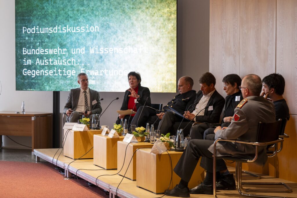 Menschen nehmen an einer Podiumsdiksussion teil