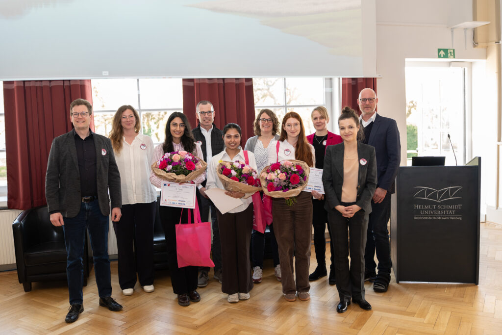 Gruppenfoto ausgezeichneter Studierender mit Urkunden und Blumen.