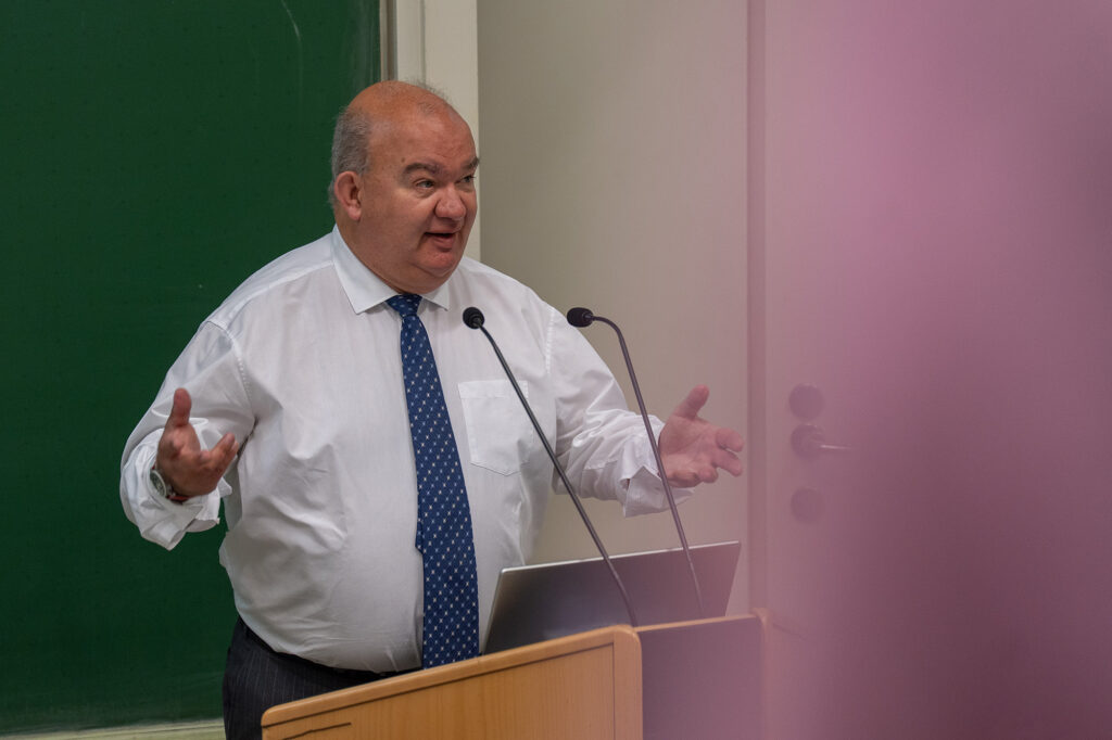 Universitätspräsident Prof. Dr. Klaus Beckmann spricht an einem Rednerpult mit zwei Mikrofonen.