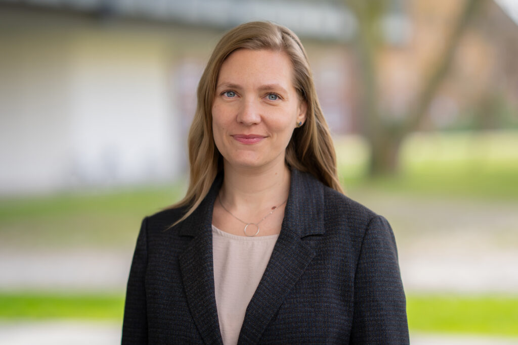 Porträt einer Person vor unscharfem Hintergrund im Außenbereich der HSU/UniBw H.