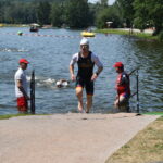 Triathlet läuft nach dem Schwimmen aus dem Wasser zur Wechselzone.