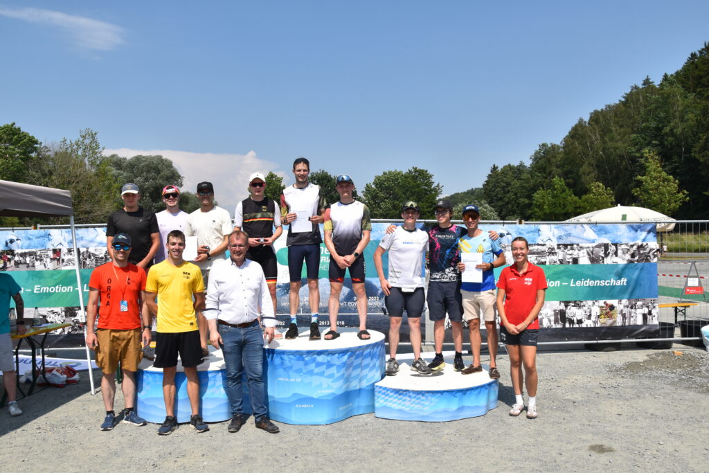 Teilnehmende stehen bei der Siegerehrung einer Triathlonmeisterschaft auf dem Siegerpodest.