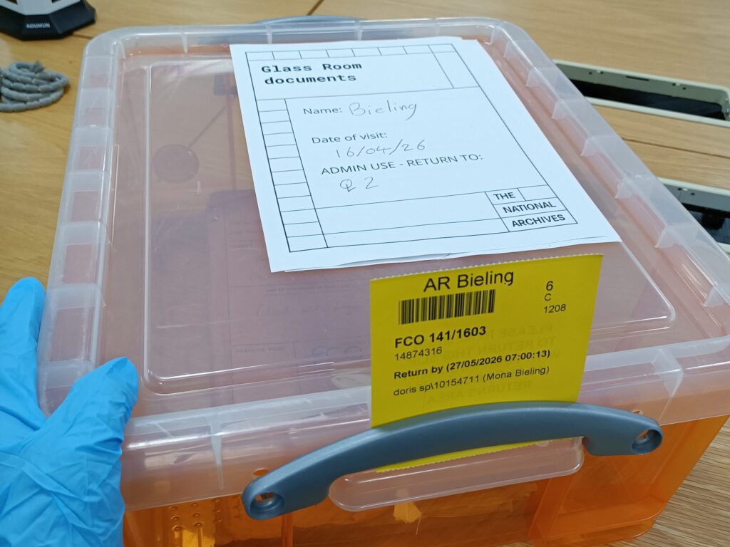 Transparente Archivbox mit gekennzeichneten Dokumentenbeständen auf einem Arbeitstisch in den National Archives London. Das Material wird als kontaminiert geführt und in einem geschlossenen Behälter bereitgestellt.